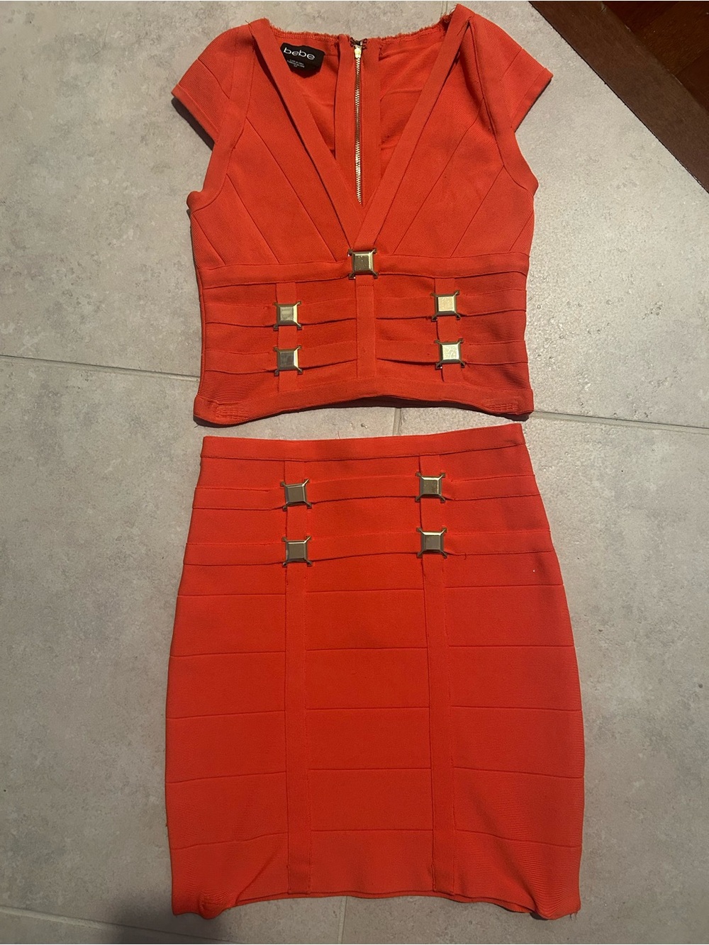 bebe Orange Two-Piece Bandage Crop Top and Skirt Set with Gold Accents